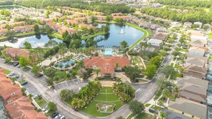 An aerial view of a residential area with a central building surrounded by a swimming pool, tennis courts, and a flagpole. - Beautiful 4bdr With Private Pool Gated Community (Almont)