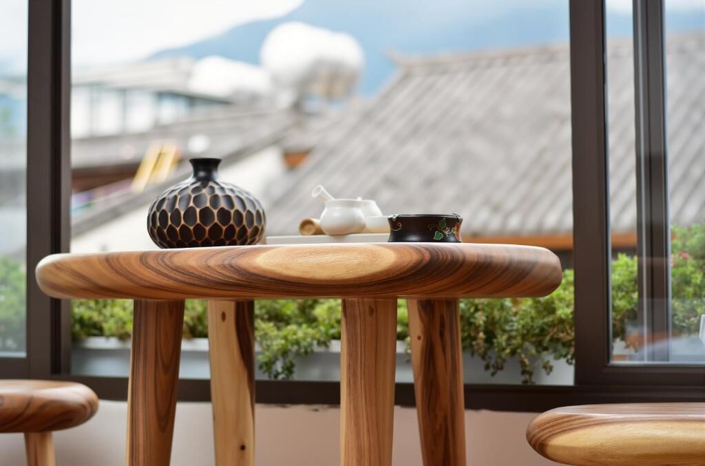 Una mesa de madera con vistas a arquitectura tradicional a través de una ventana.