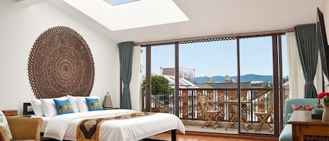 Une chambre dotée d’une lucarne, de grandes fenêtres, d’un lit, d’une chaise et d’un balcon avec vue.