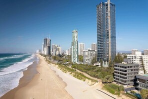 Eine Küstenstadt mit Hochhäusern, einem Sandstrand und blauem Himmel.
