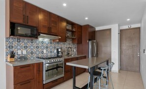 Uma cozinha moderna com armários de madeira, micro-ondas, forno, geladeira e painel de parede com padrão.
