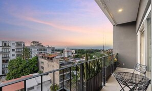 A balcony with a view of a cityscape during sunset. - Modern Apartment with a Pool (Puerto Vallarta)