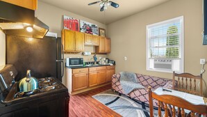 A compact kitchen with a stove, microwave, and wooden cabinets. - Lovely 1-bedroom apartment with AC in vibrant Sacramento (Sacramento)