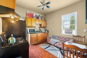 A compact kitchen with a stove, microwave, and wooden cabinets. - Lovely 1-bedroom apartment with AC in vibrant Sacramento (Sacramento)
