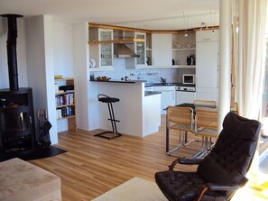 A modern kitchen with white cabinets, a central island, and a black stove. - Plattas, (Flims Fidaz), 1045 by Interhome (Flims)
