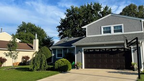 Una casa residencial con garaje, entrada para vehículos y césped bien cuidado.