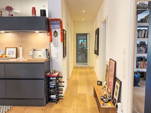 Eine moderne Küche mit Einbauherd, Weinkühlschrank und Essbereich mit Holztisch und Stühlen.