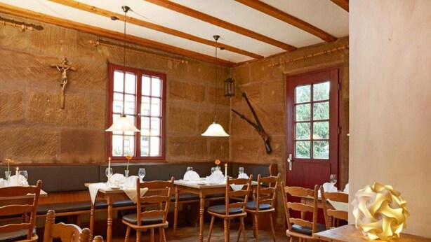 A dining area with wooden tables and chairs, stone walls, and a wooden ceiling. - 2 Person Holiday Park Home in Nuernberg (Nuremberg)