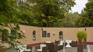 An outdoor seating area with wicker furniture and a brick floor. - 2 Person Holiday Park Home in Nuernberg (Nuremberg)