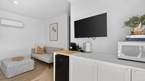 Una kitchenette con microondas, cafetera y una pequeña encimera.