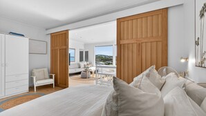 Un dormitorio moderno con una cama grande, un escritorio y vistas al exterior.