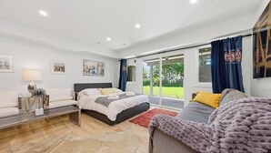 Un dormitorio moderno con cama, sofá y un ventanal grande.