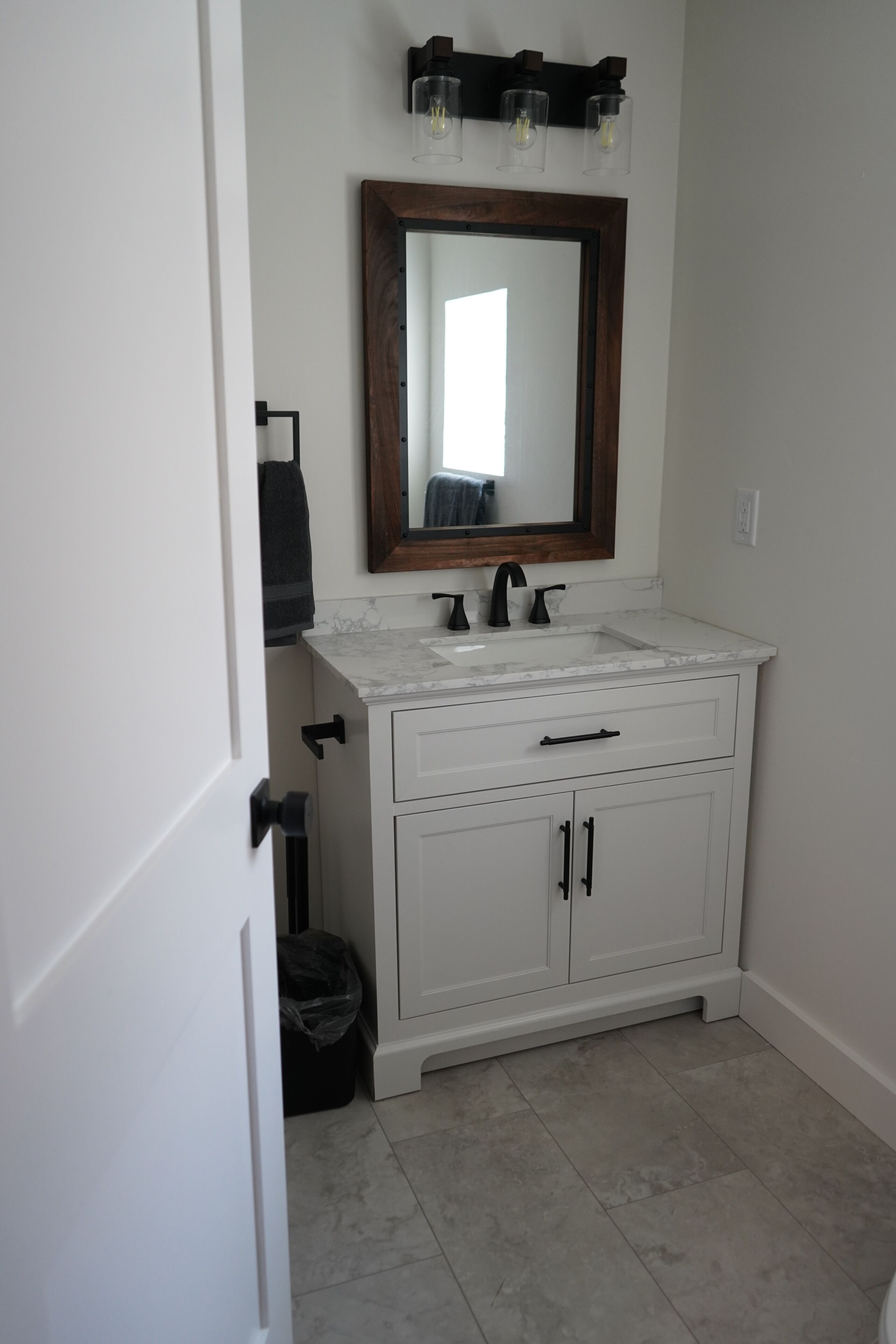 Une salle de bain avec un meuble-lavabo blanc, un miroir et un évier.
