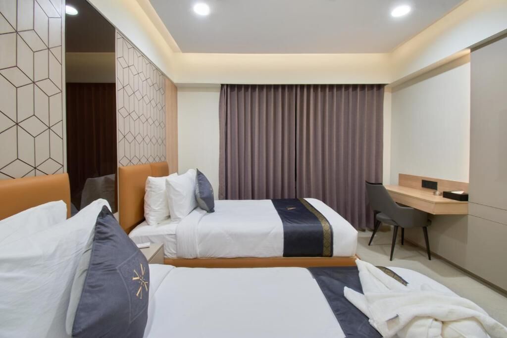Una habitación de hotel con dos camas, un escritorio y una silla.