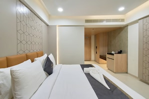 A modern hotel room with a large bed, a bathroom, and a kitchenette. - ECKO Premier V Kondapur (Hyderabad)