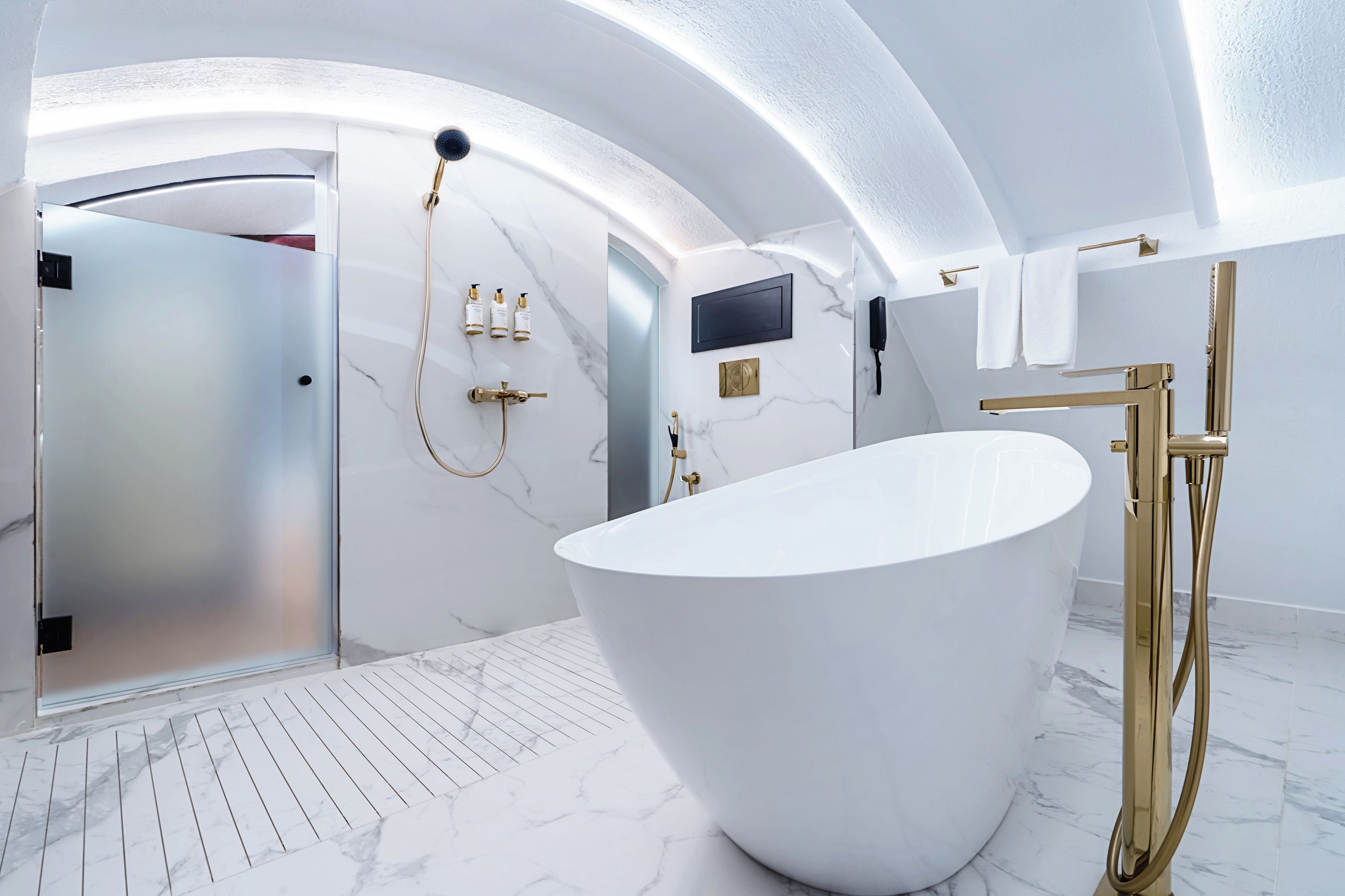 A modern bathroom with a freestanding bathtub, a vanity with a mirror, and a shower area.
