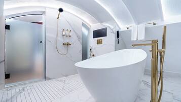 A modern bathroom with a freestanding bathtub, a vanity with a mirror, and a shower area.