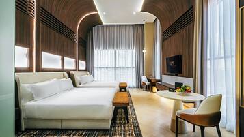 Una habitación de hotel moderna con una cama grande, un escritorio, una silla y una mesa de comedor.
