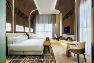Una habitación de hotel moderna con una cama grande, un escritorio, una silla y una mesa de comedor.
