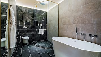 A modern bathroom with a freestanding bathtub, a glass-enclosed shower, and a toilet.