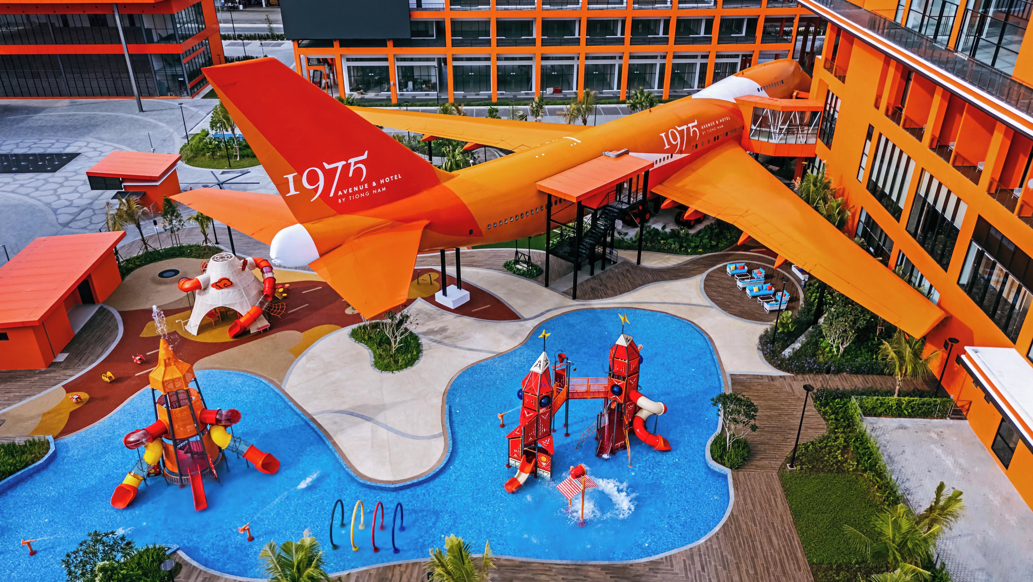 A water park with a large airplane-shaped play structure and a swimming pool.