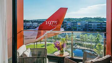 A balcony with a view of a cityscape and a large airplane tail.