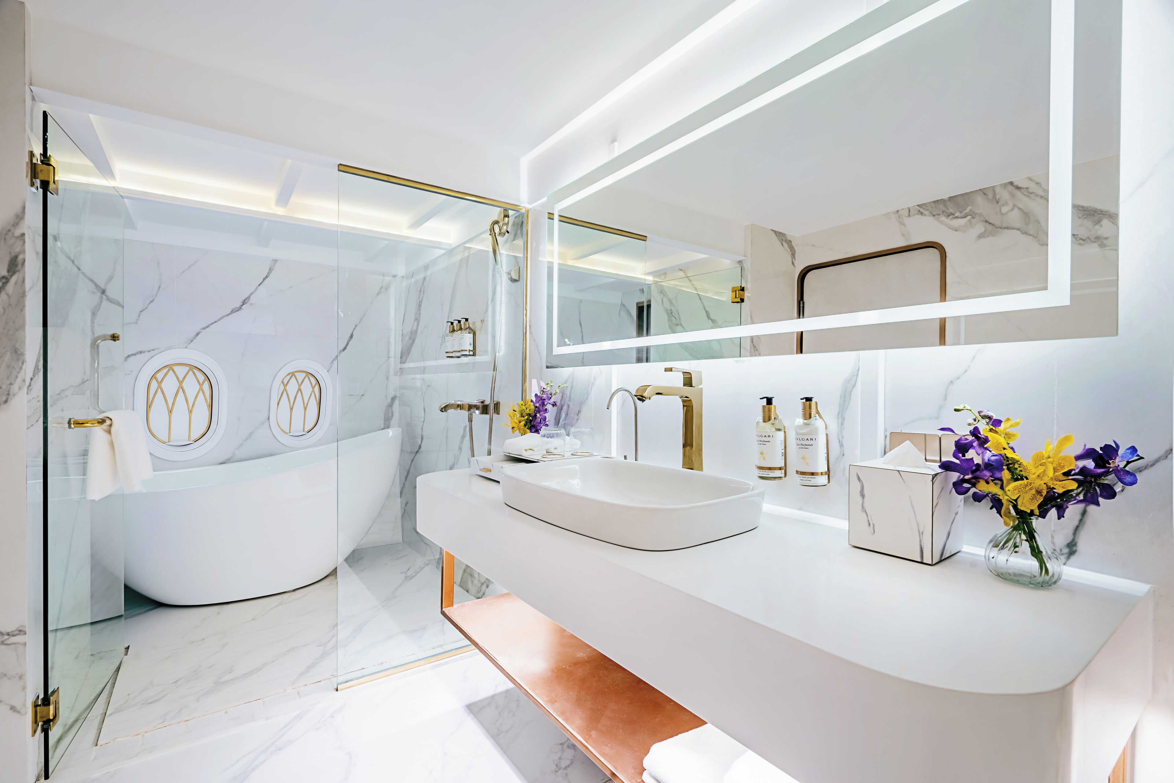 A modern bathroom with a freestanding bathtub, a vanity with a sink, and a large mirror.