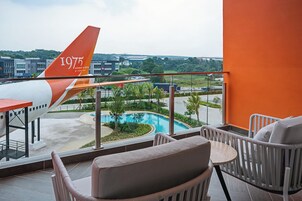 A balcony with a view of an airplane and a swimming pool.