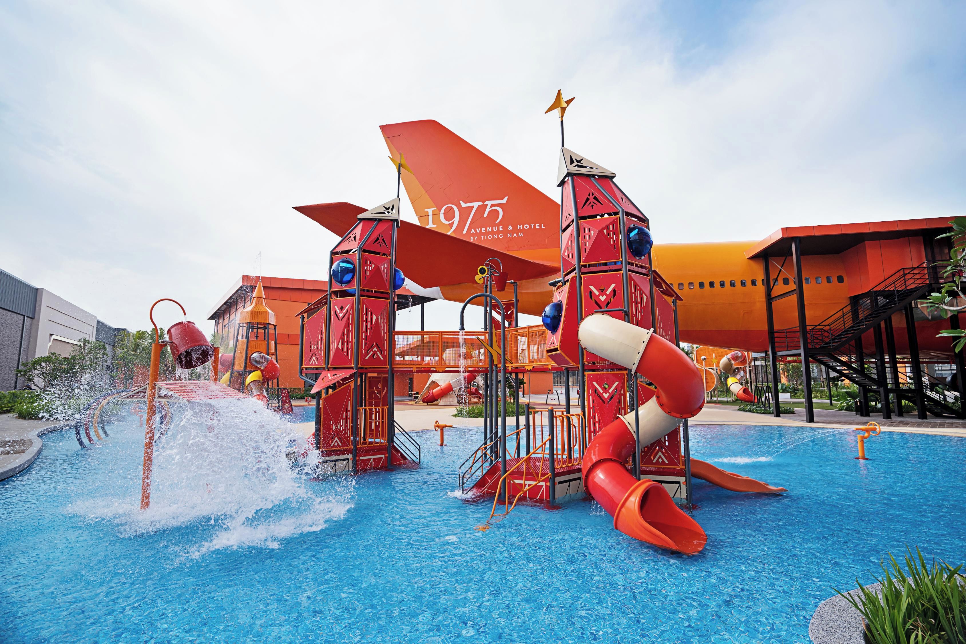 A water park with slides and a pool, surrounded by buildings.
