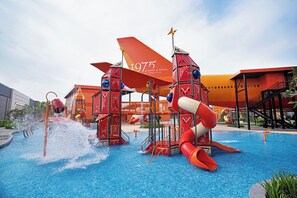 Un parc aquatique avec des toboggans et une piscine, entouré de bâtiments.