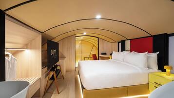 A modern hotel room with a bed, bedside table, and a television.