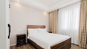 Ein Schlafzimmer mit einem hölzernen Bett, einem Nachttisch und einer Wandleuchte.