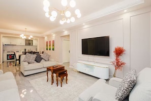 Ein stilvolles Wohnzimmer mit Sofa, Couchtisch und Fernseher.