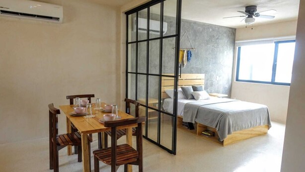 A bedroom with a bed, a bedside table, and a window. - Boho 1-Bedroom Apartment with Fast Wi-Fi in Downtown, Perfect for Working Near the Hotel District (Cancún)