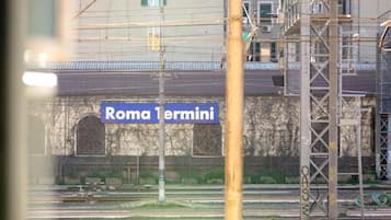 A railway station platform with a sign reading 'Roma Termini'.