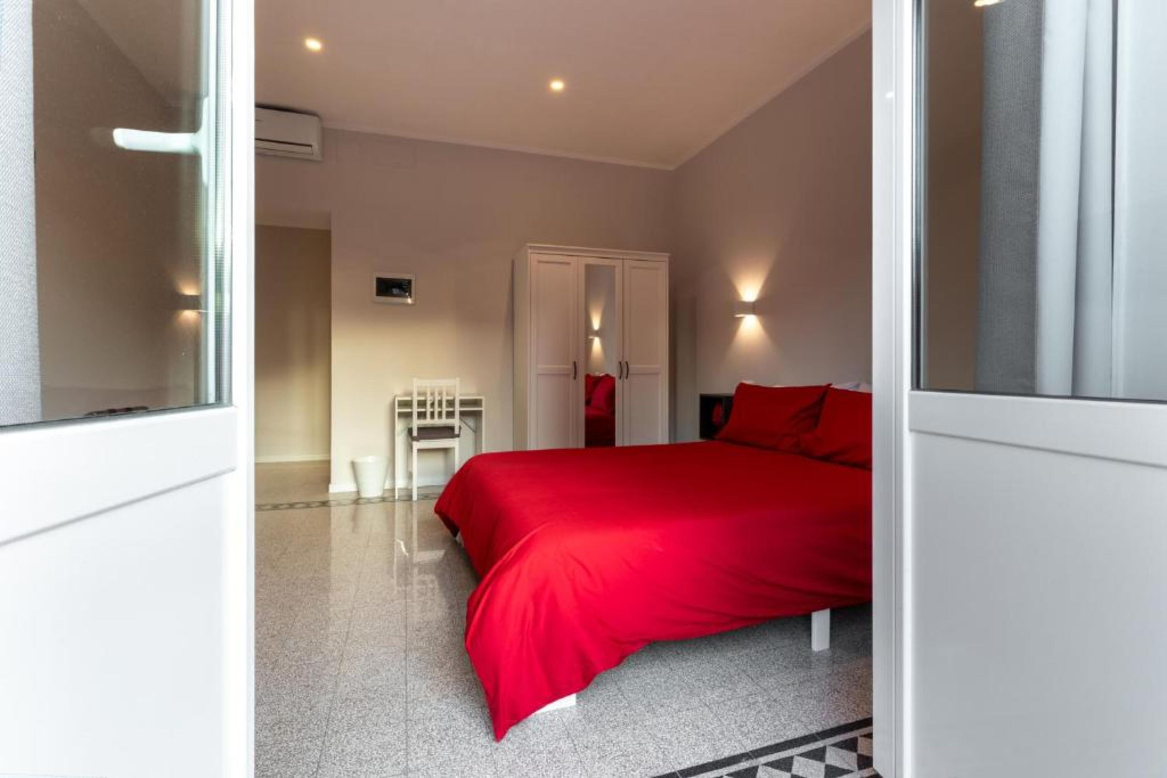 A bedroom with a bed, a wardrobe, and a desk.