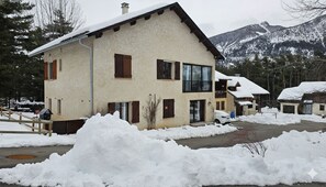 Ein zweistöckiges Gebäude mit einem geneigten Dach, Holzhörnern und großen Fenstern.