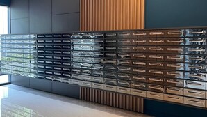 Ein modernes Interieur mit einem glänzenden Stauraumelement, eingelassener Beleuchtung und einer Kombination aus dunklen und hellen Wandpaneelen.