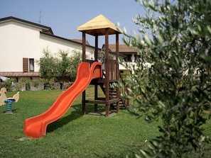Ein Spielplatz mit einer Rutsche und einer Holzspielanlage.