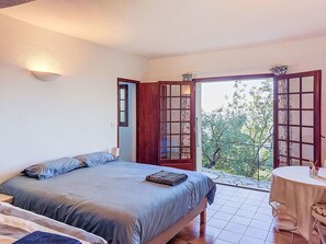 A bedroom with a bed, a table, and a balcony with a view. - Balcon d´Azur by Interhome (Spéracèdes)