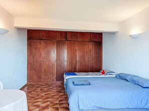 Une chambre à coucher avec un lit, une armoire et une chaise.