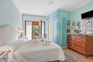 A bedroom with a bed, dresser, and wall art.
