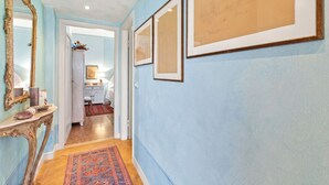 A hallway with a light blue wall, a mirror, and framed artwork. - Roma 62 Lake View,terrace & Private Park (Toscolano Maderno)