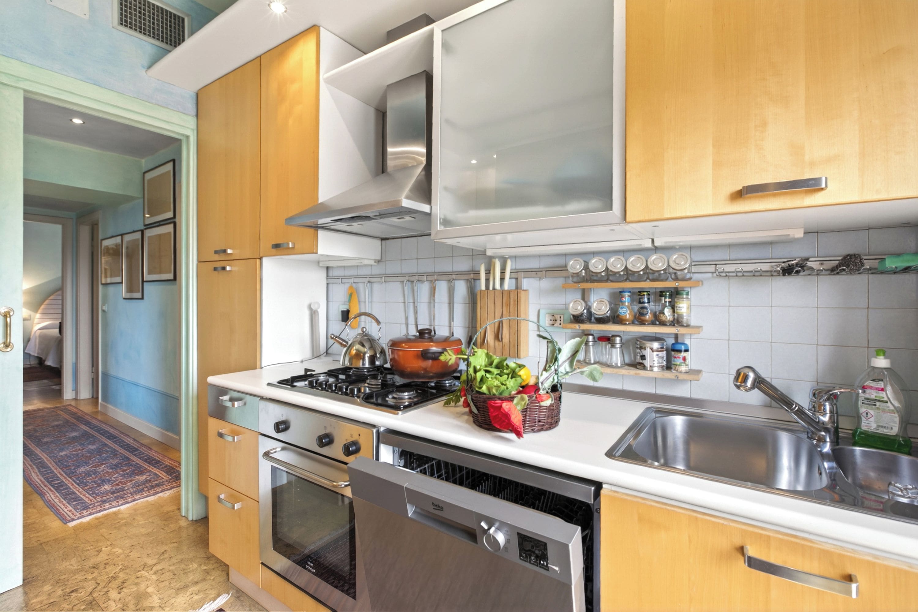 A modern kitchen with stainless steel appliances, wooden cabinets, and a built-in oven.