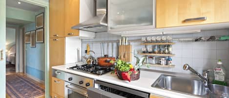 A modern kitchen with stainless steel appliances, wooden cabinets, and a built-in oven.