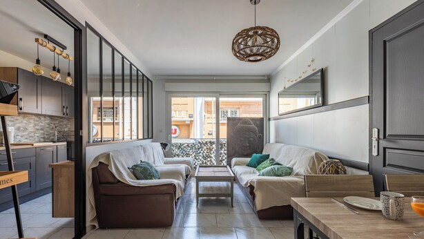 Una sala de estar moderna con un conjunto de sofás, una mesa de comedor y un espejo grande.