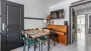 Un comedor con una mesa de madera, sillas y un televisor montado en la pared.