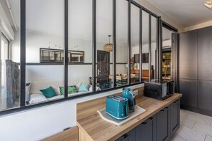 A modern kitchen with a large window, a wooden countertop, and a built-in oven. - Design 2BR | Private Parking, Beach & Train (Golfe Juan Vallauris)