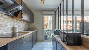 Una cocina moderna con horno integrado, microondas y cafetera.