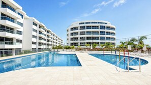 A modern hotel with a large outdoor swimming pool, multiple balconies, and a central courtyard. - Apto moderno en Serena con balcon  (Cartagena)